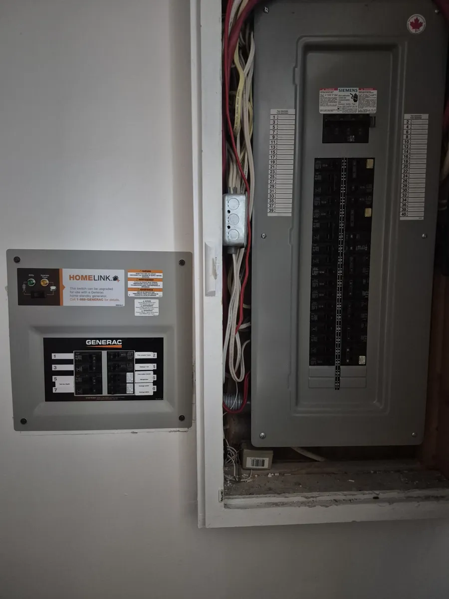 Inverseur manuel Generac pour génératrice installé à côté d'un panneau électrique Siemens